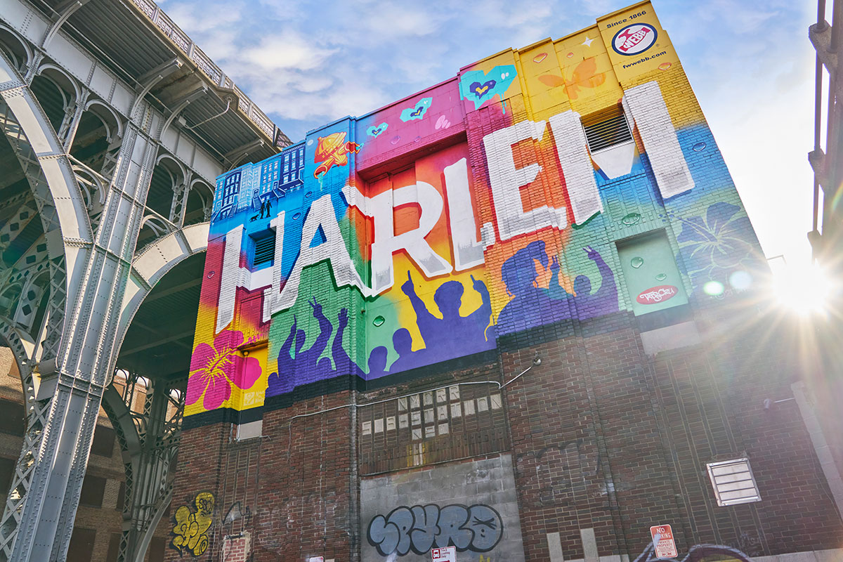 Colorful mural spelling out -Harlem- on upper floor of brick building