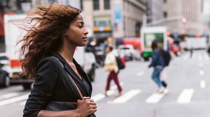 An African-American woman crosses the street in NYC