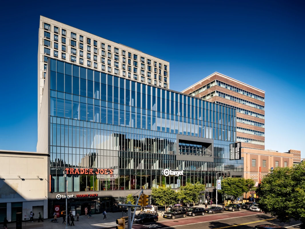 Modern commercial building with Trader Joe’s and Target storefronts under a glass curtain facade