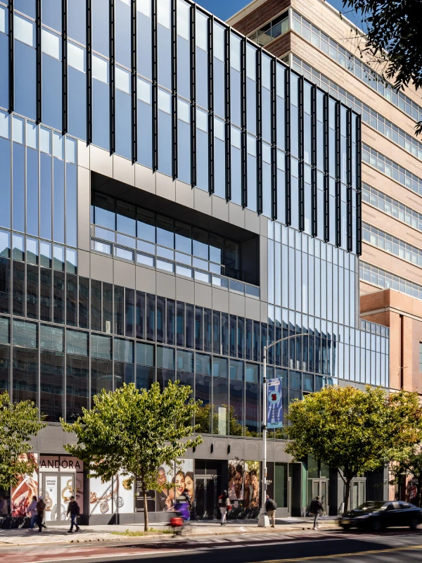 Street-level view of popular retailers with pedestrians and traffic in an urban commercial zone